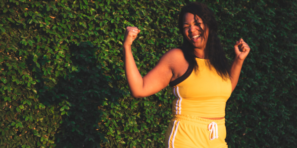 Woman smiling and holding her arms up in victory.
