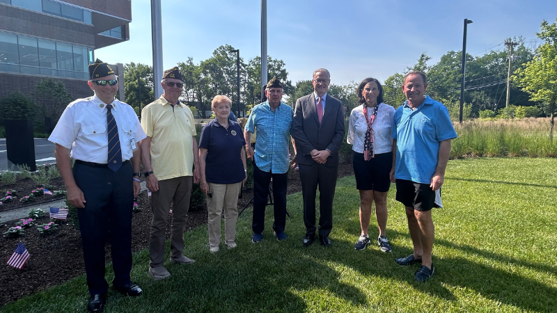 men and women posing for photo at flag day ceremony