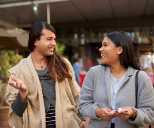 Two LGBTQ+ friends talking and laughing while shopping