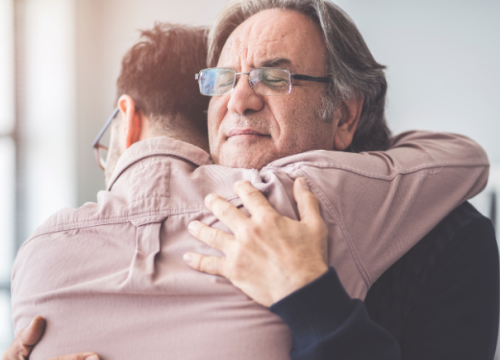 Father and adult son hugging