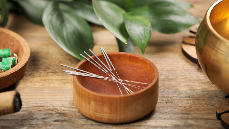 Acupuncture needles in a wooden bowl