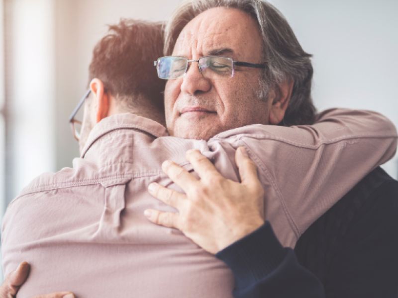 Father and adult son hugging